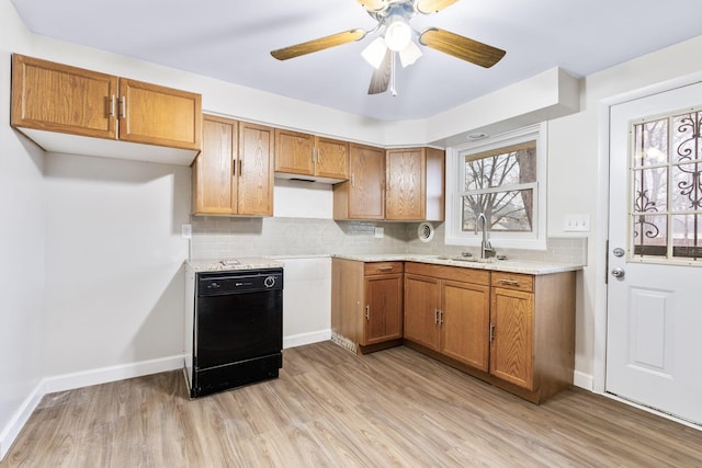 kitchen featuring light wood-style flooring, brown cabinets, a sink, light countertops, and backsplash