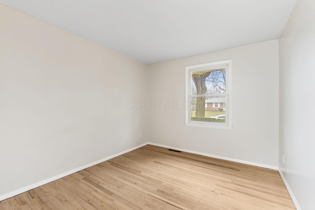 unfurnished room with baseboards, visible vents, and light wood-style floors