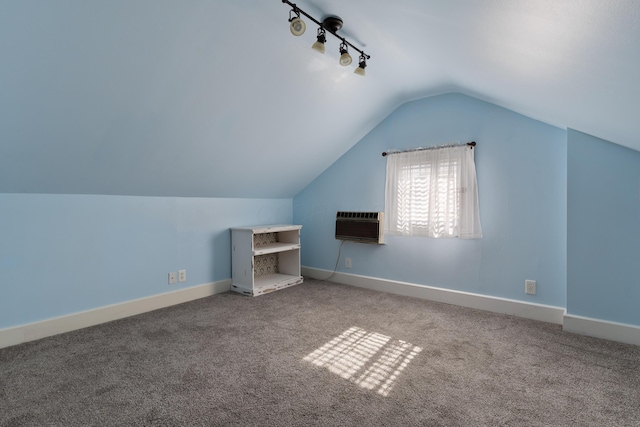 additional living space with lofted ceiling, an AC wall unit, carpet flooring, and baseboards