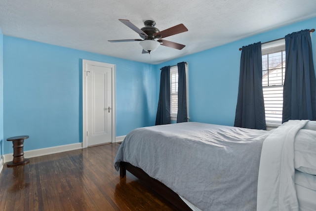 bedroom with baseboards, dark wood finished floors, and a textured ceiling