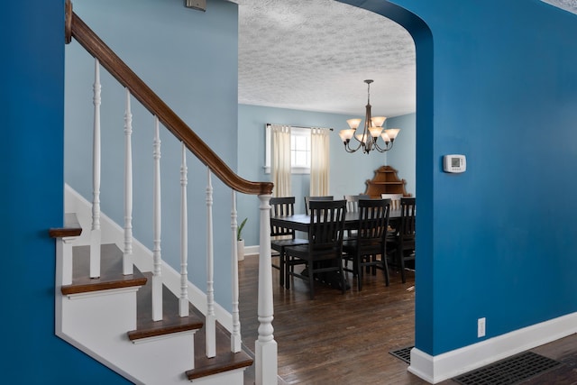 dining area with dark wood-style floors, stairway, baseboards, and a textured ceiling