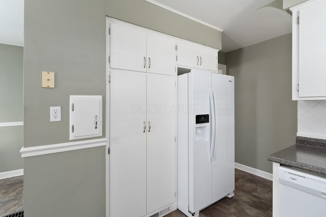 kitchen featuring white appliances, baseboards, white cabinets, decorative backsplash, and dark countertops