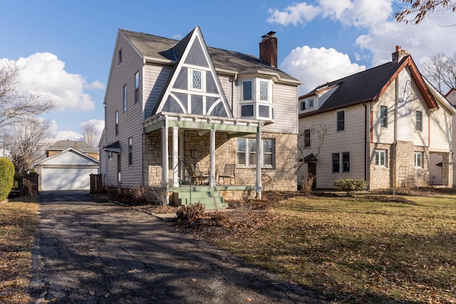 view of front facade with a porch, stone siding, and an outdoor structure