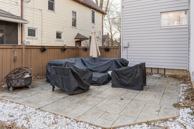 view of patio featuring an outdoor fire pit and fence