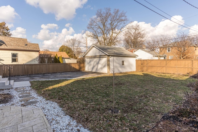 view of yard featuring a garage, an outbuilding, and a fenced backyard