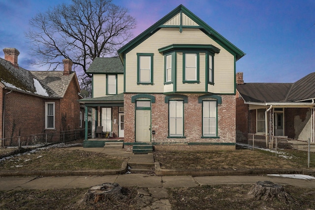 victorian home with fence private yard and brick siding