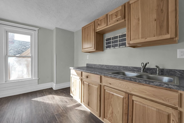 kitchen featuring dark countertops, a sink, and a healthy amount of sunlight