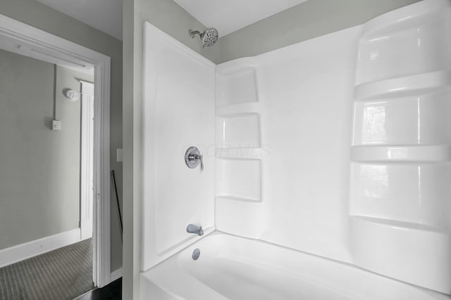 bathroom with bathtub / shower combination and baseboards