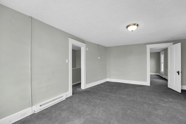 spare room with baseboard heating, dark carpet, a textured ceiling, and baseboards