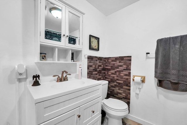 bathroom with baseboards, vanity, and toilet