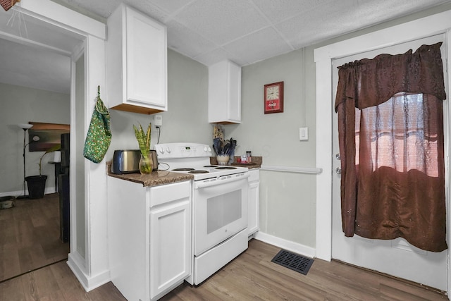 kitchen with electric range, visible vents, white cabinets, dark countertops, and light wood-style flooring