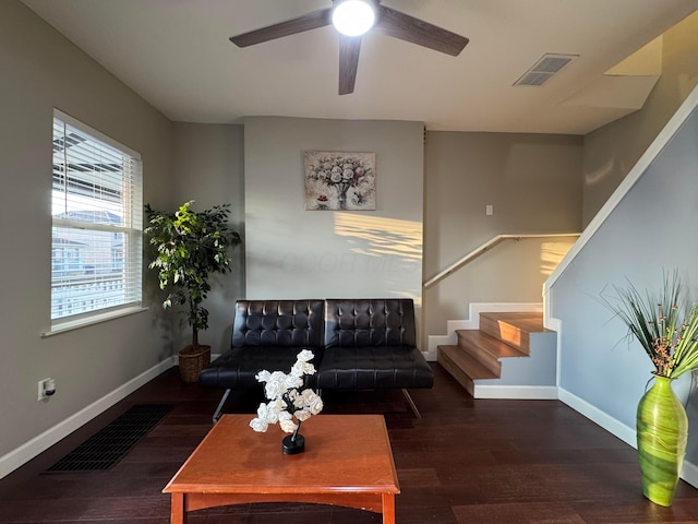 living area with dark wood-type flooring, visible vents, stairway, and baseboards