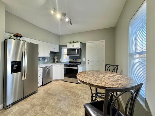 kitchen featuring appliances with stainless steel finishes, white cabinets, light countertops, and tasteful backsplash