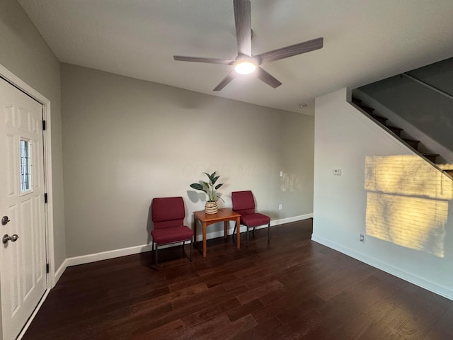 sitting room featuring dark wood-style floors, ceiling fan, stairway, and baseboards