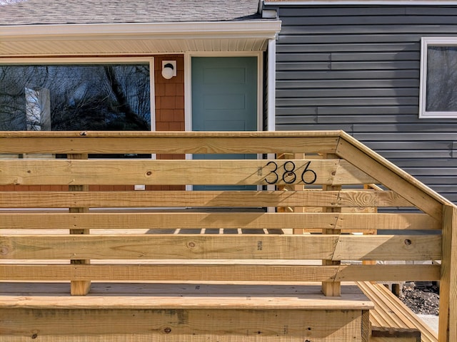 view of exterior entry with roof with shingles