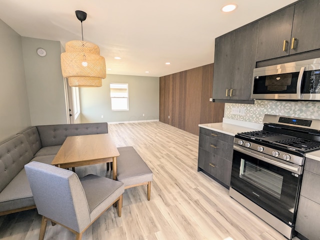 kitchen with light wood-style flooring, recessed lighting, light countertops, appliances with stainless steel finishes, and pendant lighting