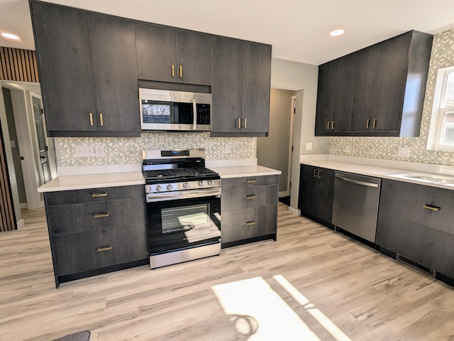 kitchen with dark brown cabinetry, stainless steel appliances, and light countertops