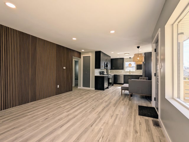 living area featuring baseboards, recessed lighting, visible vents, and light wood-style floors