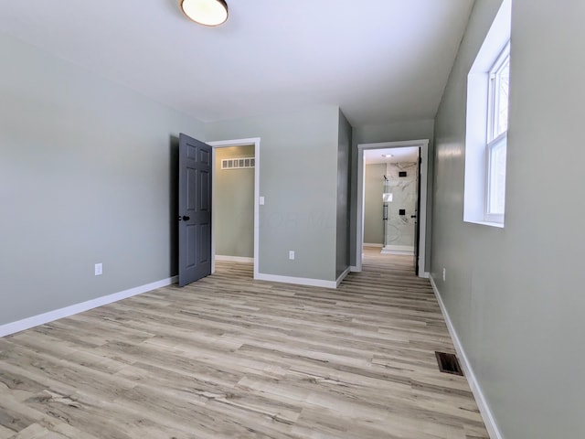 unfurnished bedroom featuring light wood-style floors, visible vents, and baseboards