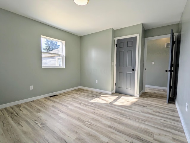 unfurnished bedroom with baseboards, visible vents, and light wood finished floors