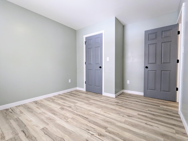 unfurnished bedroom featuring baseboards and light wood-style floors