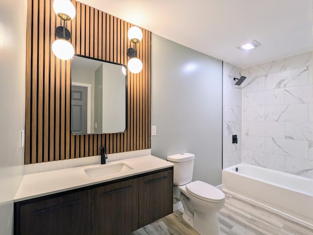 bathroom with toilet, tub / shower combination, wood finished floors, and vanity