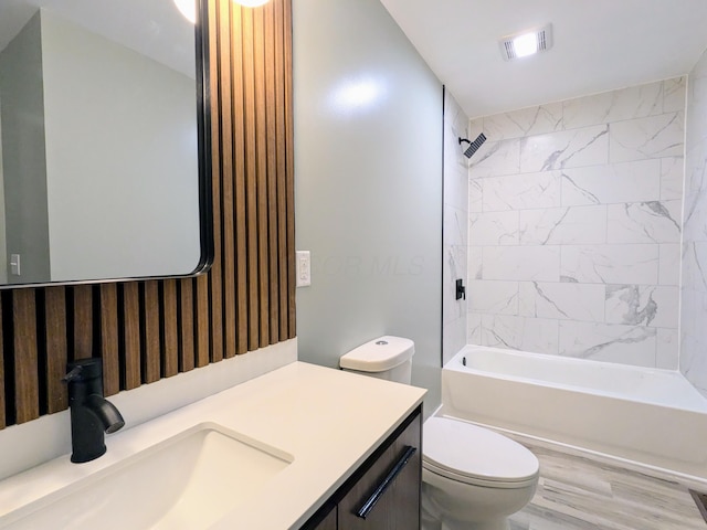 full bath with visible vents, toilet, wood finished floors,  shower combination, and vanity