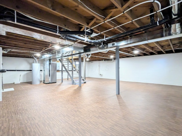 unfinished below grade area featuring water heater, stairway, wood finished floors, and heating unit