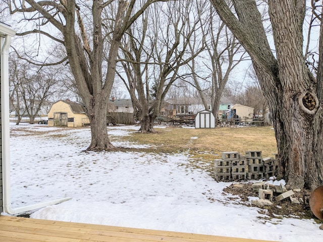 snowy yard with an outbuilding and a storage unit