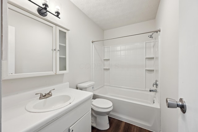 full bathroom with a textured ceiling, toilet, wood finished floors, vanity, and  shower combination