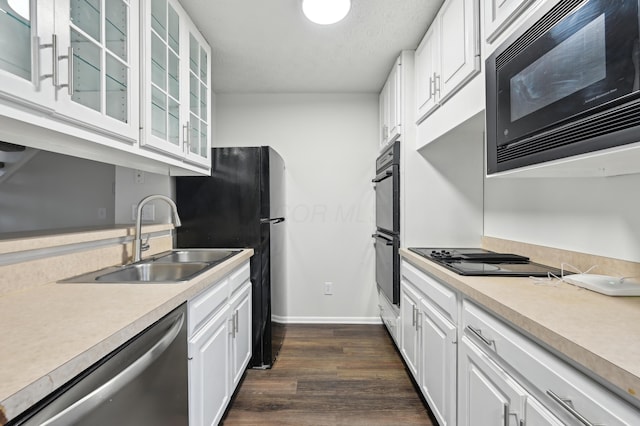 kitchen with black appliances, a sink, and white cabinets