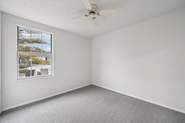 carpeted empty room featuring a textured ceiling, a ceiling fan, and baseboards