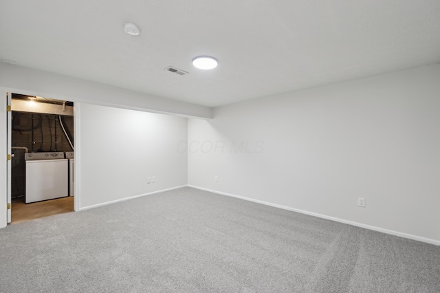 carpeted empty room featuring baseboards, visible vents, and independent washer and dryer