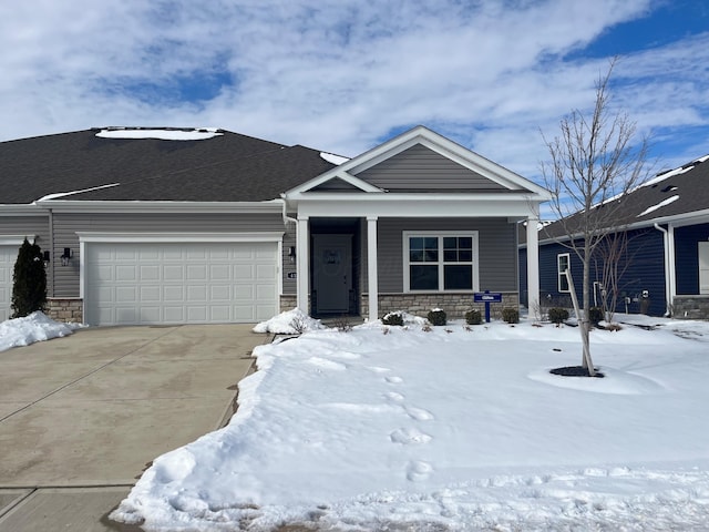 view of front of house with a porch, a garage, stone siding, driveway, and roof with shingles