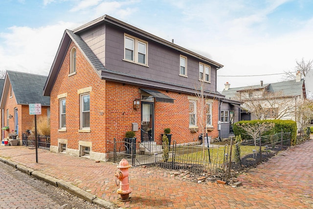 view of front facade featuring a fenced front yard and brick siding