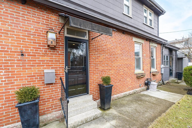 doorway to property featuring brick siding