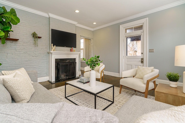 living room with a fireplace, ornamental molding, a wealth of natural light, and wood finished floors