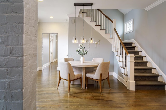 dining room featuring crown molding, stairs, baseboards, and wood finished floors