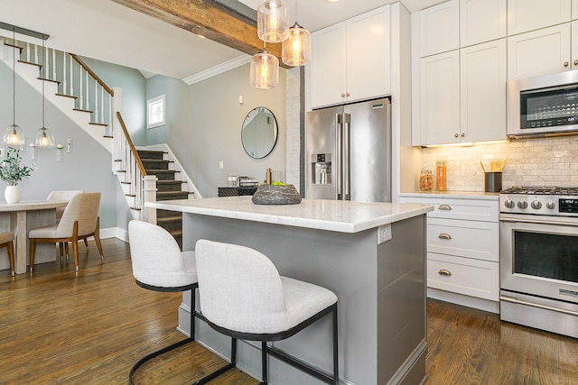 kitchen featuring dark wood-style flooring, decorative light fixtures, stainless steel appliances, backsplash, and white cabinets