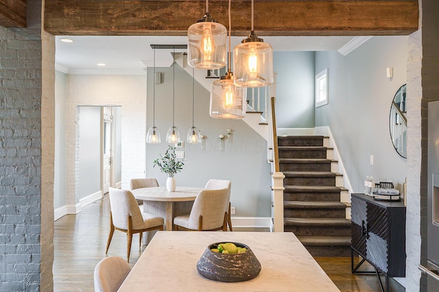 dining room featuring dark wood-style floors, ornamental molding, stairway, and baseboards