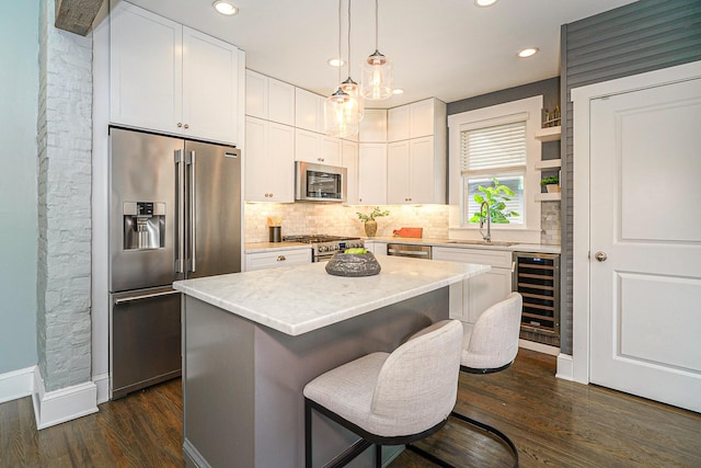 kitchen with stainless steel appliances, beverage cooler, white cabinets, and backsplash