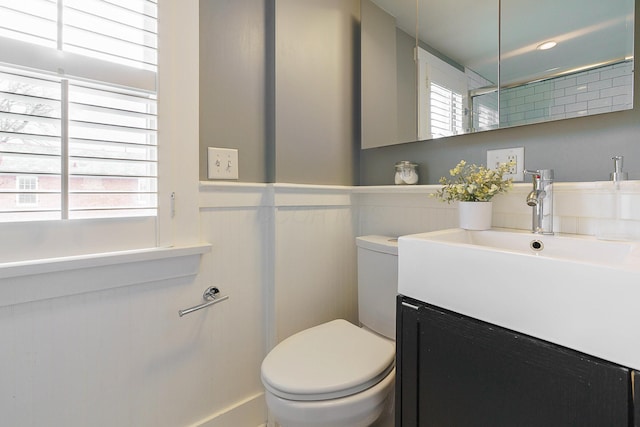 bathroom featuring a wainscoted wall, vanity, and toilet