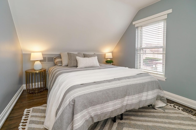 bedroom featuring vaulted ceiling, wood finished floors, and baseboards