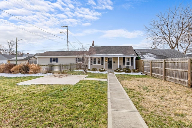 view of front of house featuring fence private yard, a patio area, and a front yard