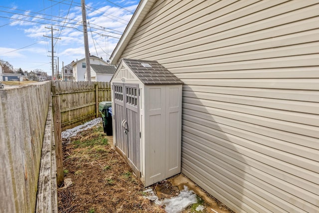 exterior space featuring an outbuilding, fence, and a storage unit