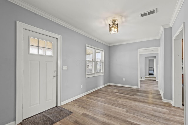 foyer entrance with light wood finished floors, visible vents, baseboards, and crown molding