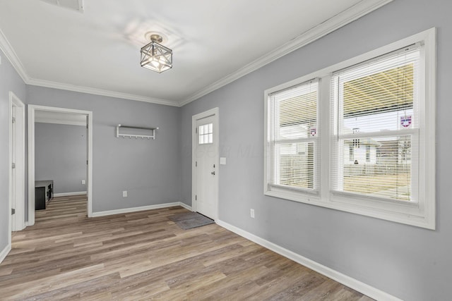 entryway with ornamental molding, baseboards, and light wood finished floors