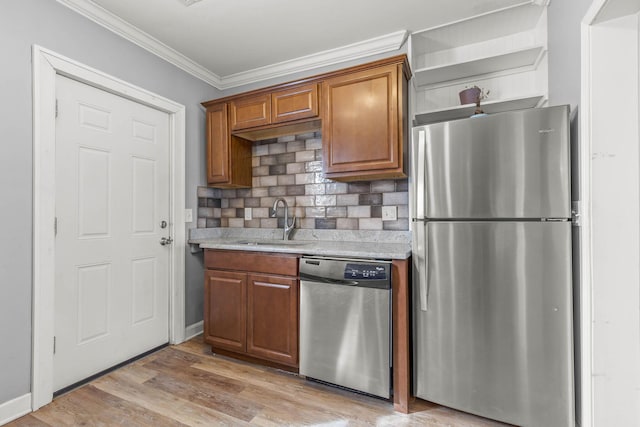 kitchen with brown cabinets, stainless steel appliances, crown molding, light wood-style floors, and a sink