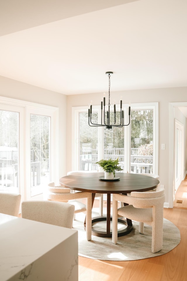 unfurnished dining area featuring light wood-type flooring and a notable chandelier