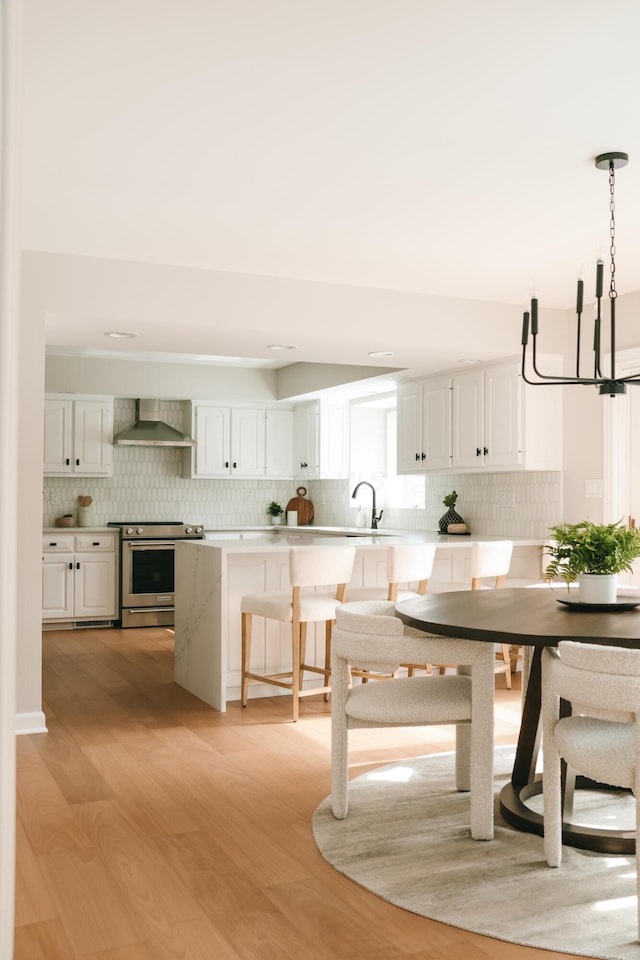 unfurnished dining area with light wood-type flooring, a notable chandelier, and a sink